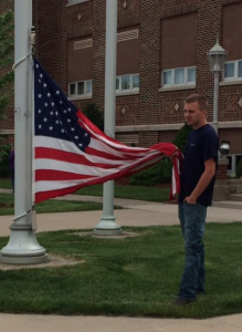 Cole D., waits for help, holding the American flag. (Photo credit: WTVM/ Rhonda Ordway Pester)